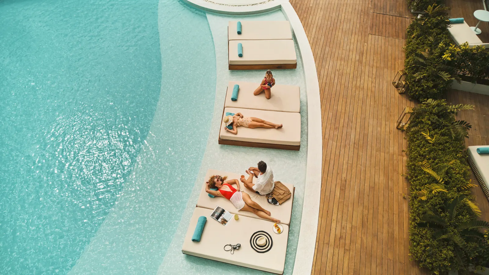 Aerial view of a curved infinity pool with daybeds on a timber deck at Radisson Collection Resort & Spa, Galle