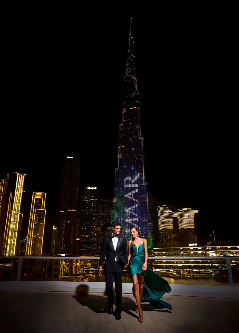 Guests on the terrace at Address Downtown with the Burj Khalifa lit behind