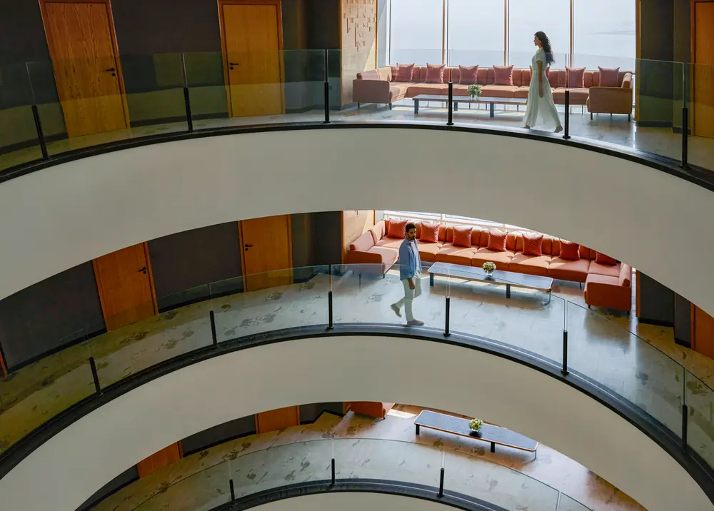 The curved balconies of the atrium at Andaz Doha, seen from above