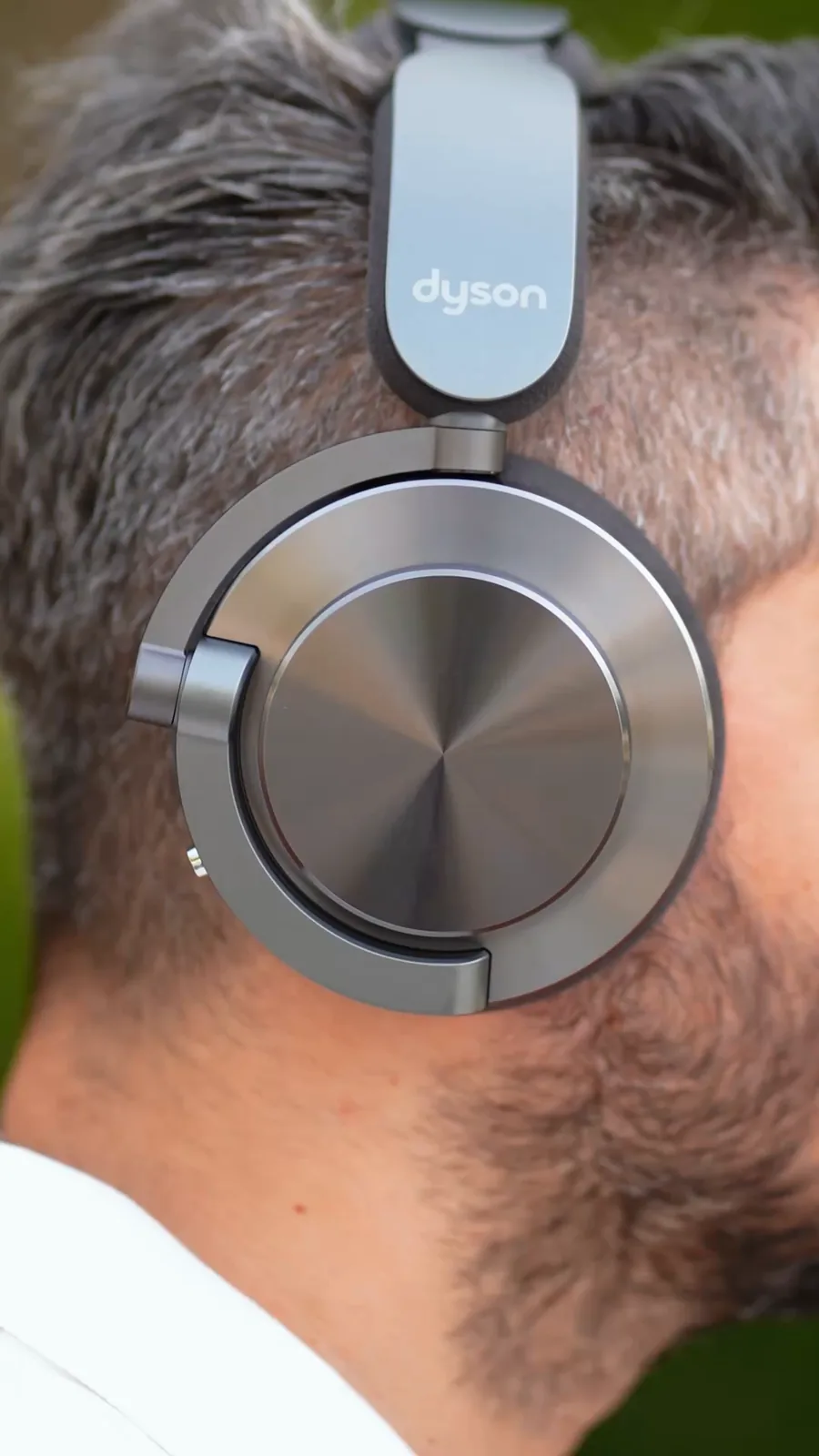 Close-up of a man wearing Dyson OnTrac headphones, framed vertically for social media