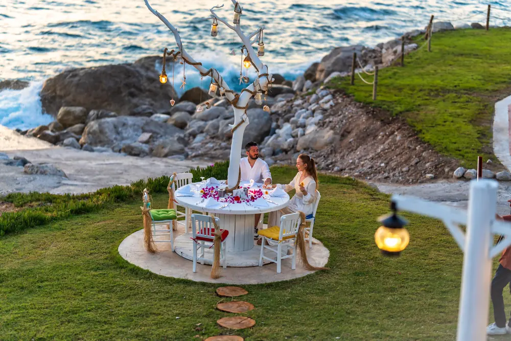 A private table laid for two on the lawn above the sea at Liberty Lykia